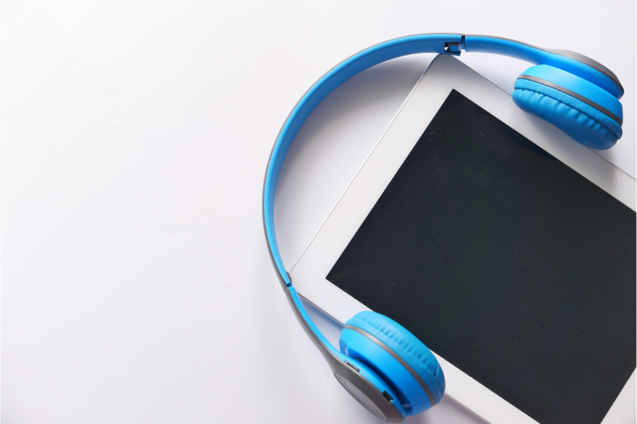 photo of a tablet with a blue pair of headphones